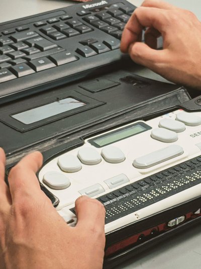 Person nutzt Braille-Zeile